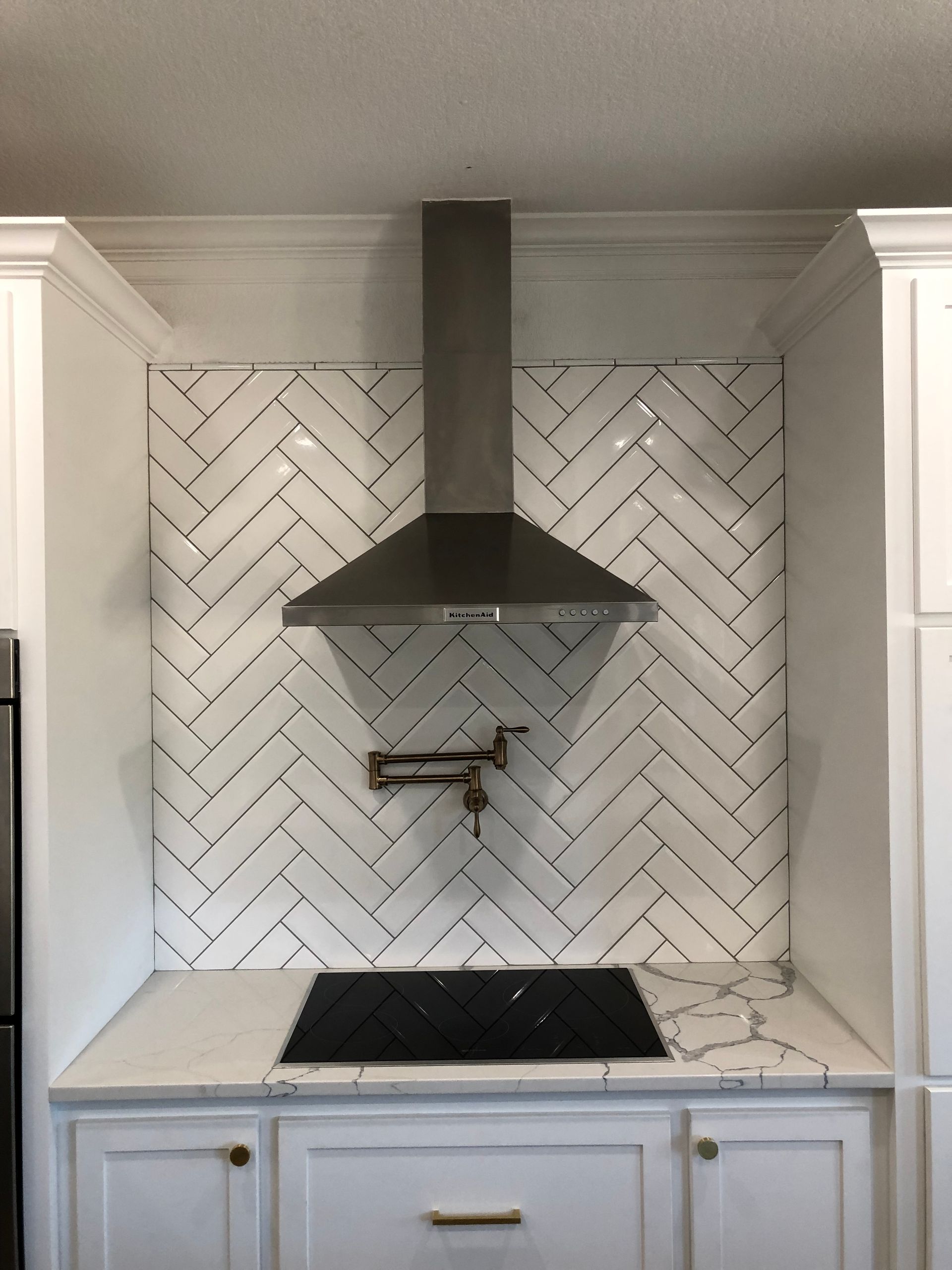 A kitchen with white cabinets and a stove top oven