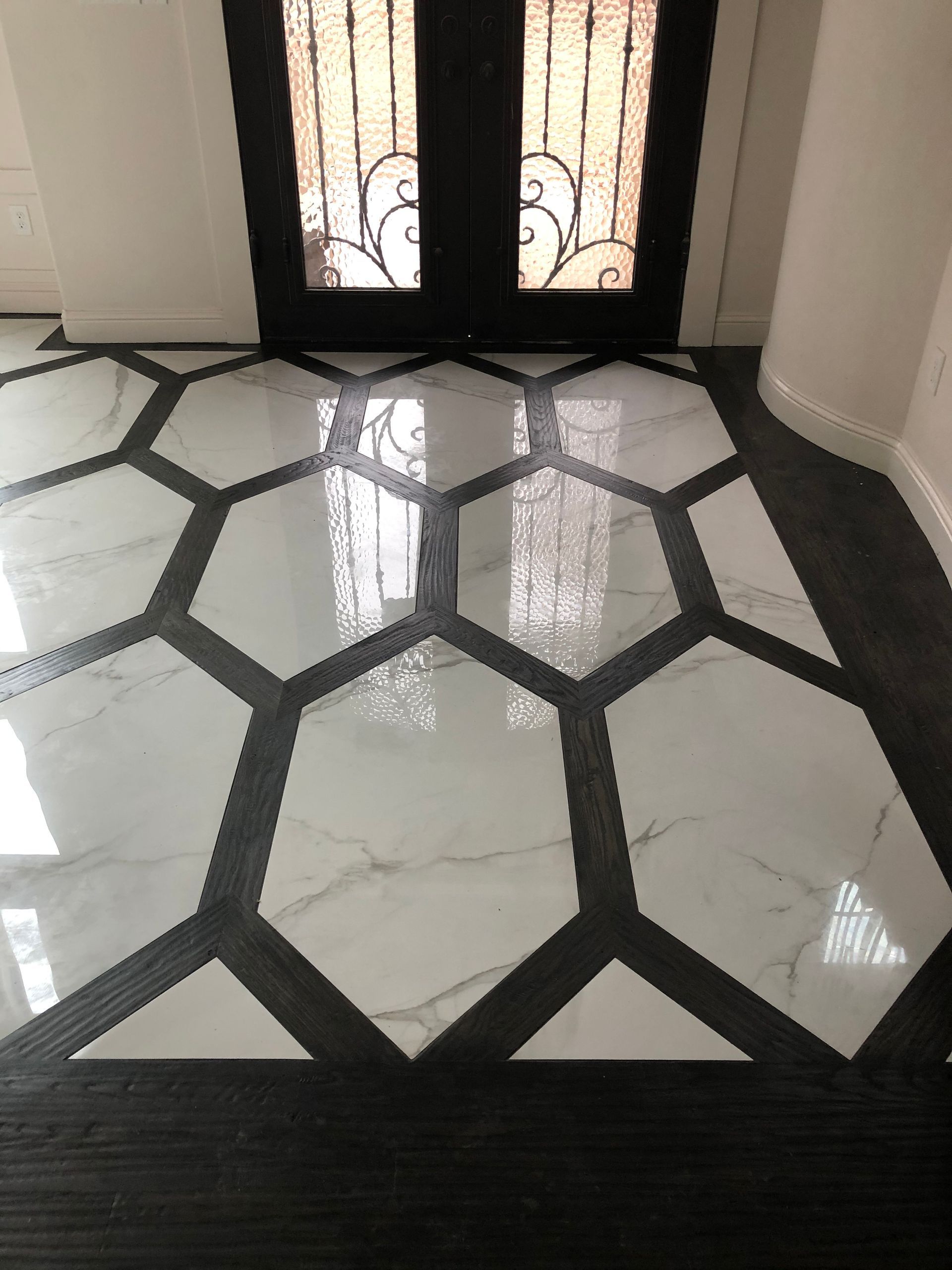 A black and white tile floor with a hexagon pattern in a hallway.