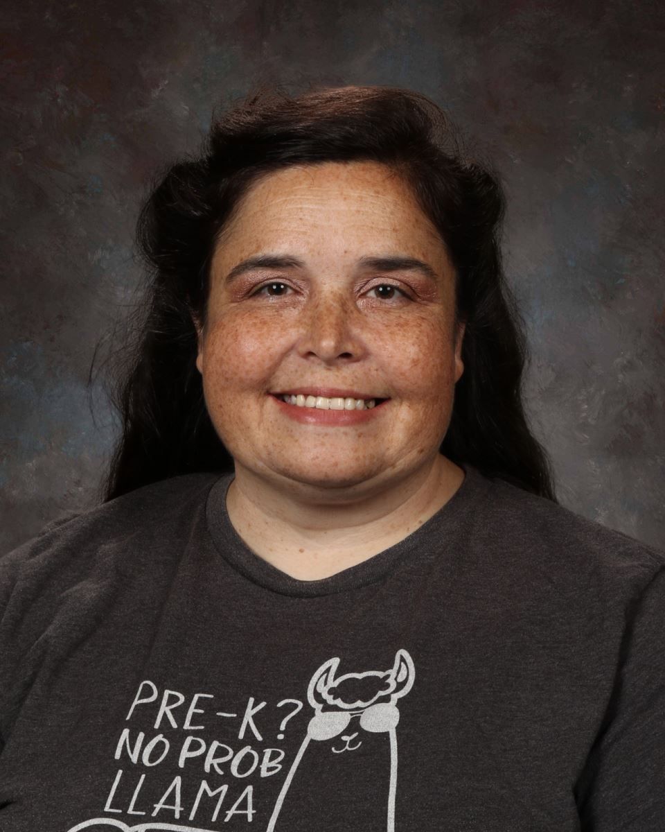 A woman in a floral shirt is smiling for the camera.