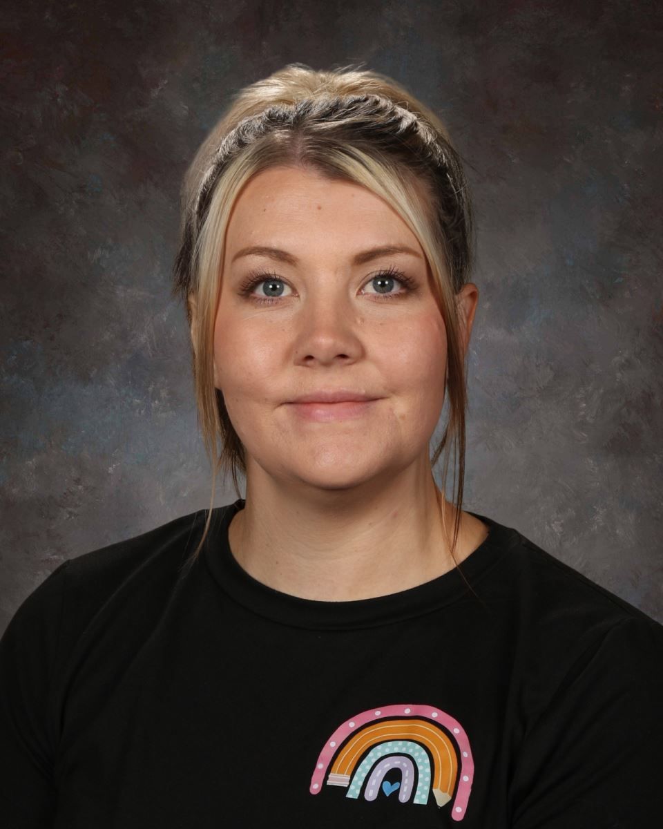 A woman wearing a black vest and a white shirt