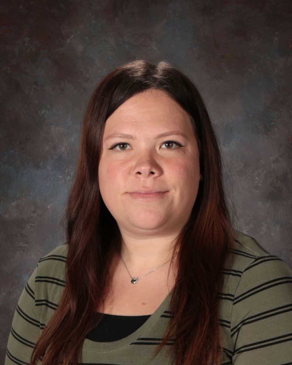 A woman in a striped shirt is smiling for the camera