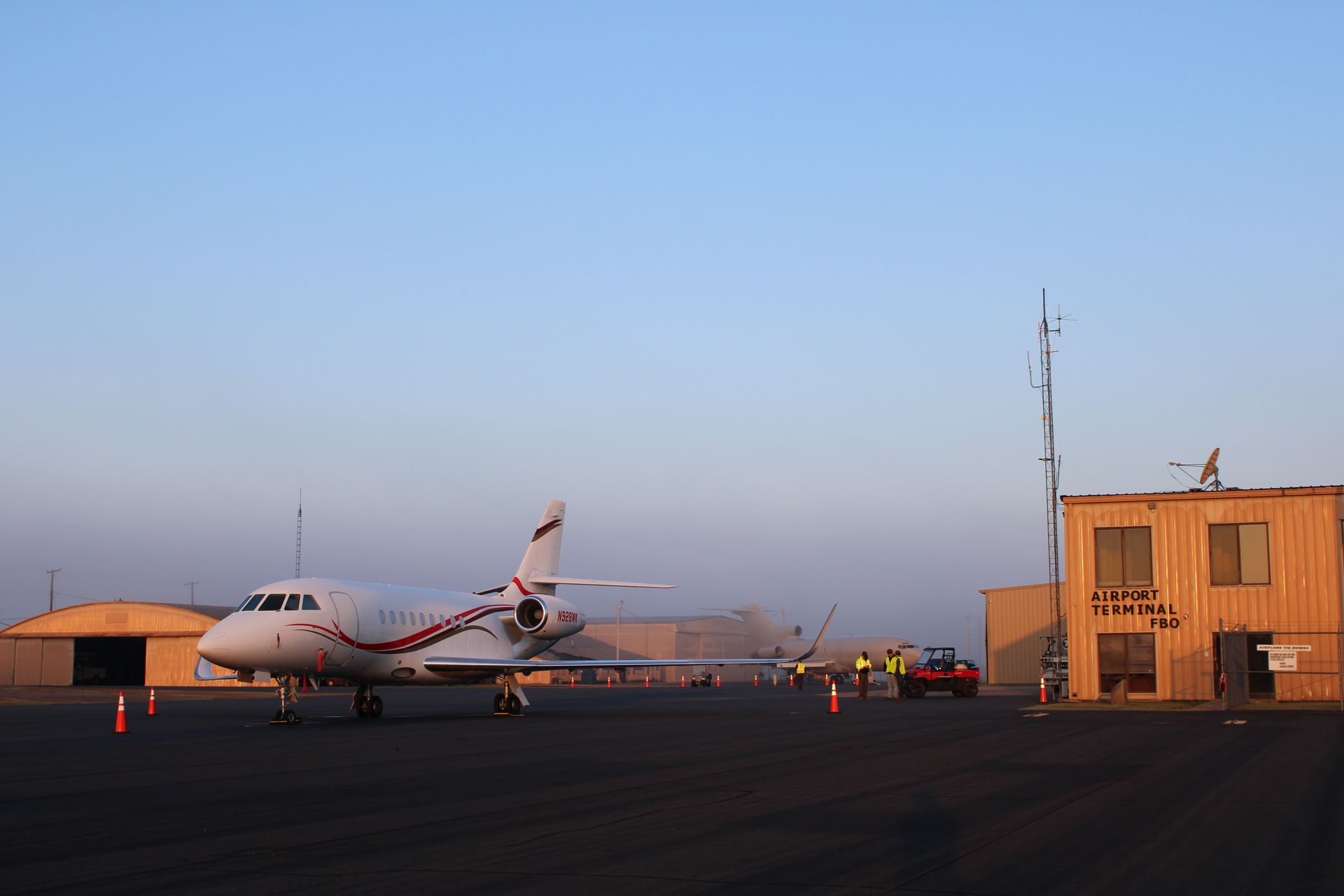 A private jet parked on an airport tarmac next to a building labeled 