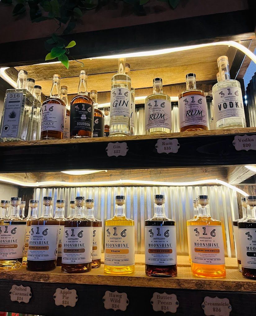 Lit liquor bottles displayed on wooden shelves with warm backlighting and handwritten price tags
