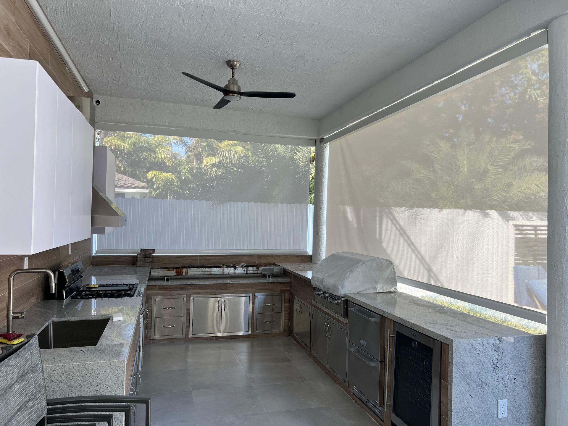 A kitchen with a sink , stove , and ceiling fan.