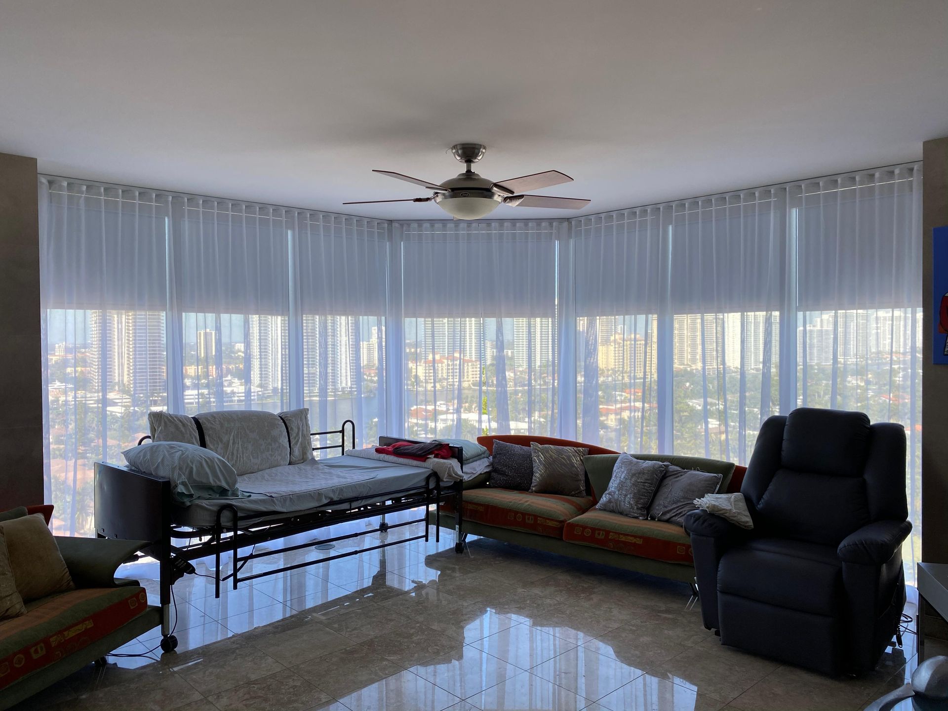 A living room with a couch , chair , and ceiling fan.