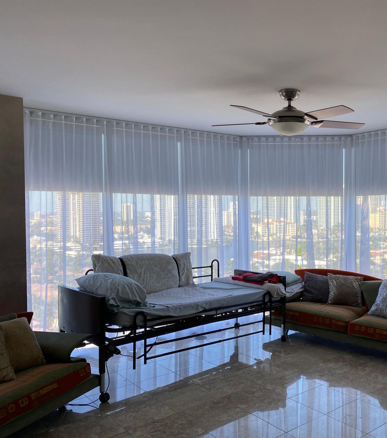 A living room with a couch , chair , and ceiling fan.