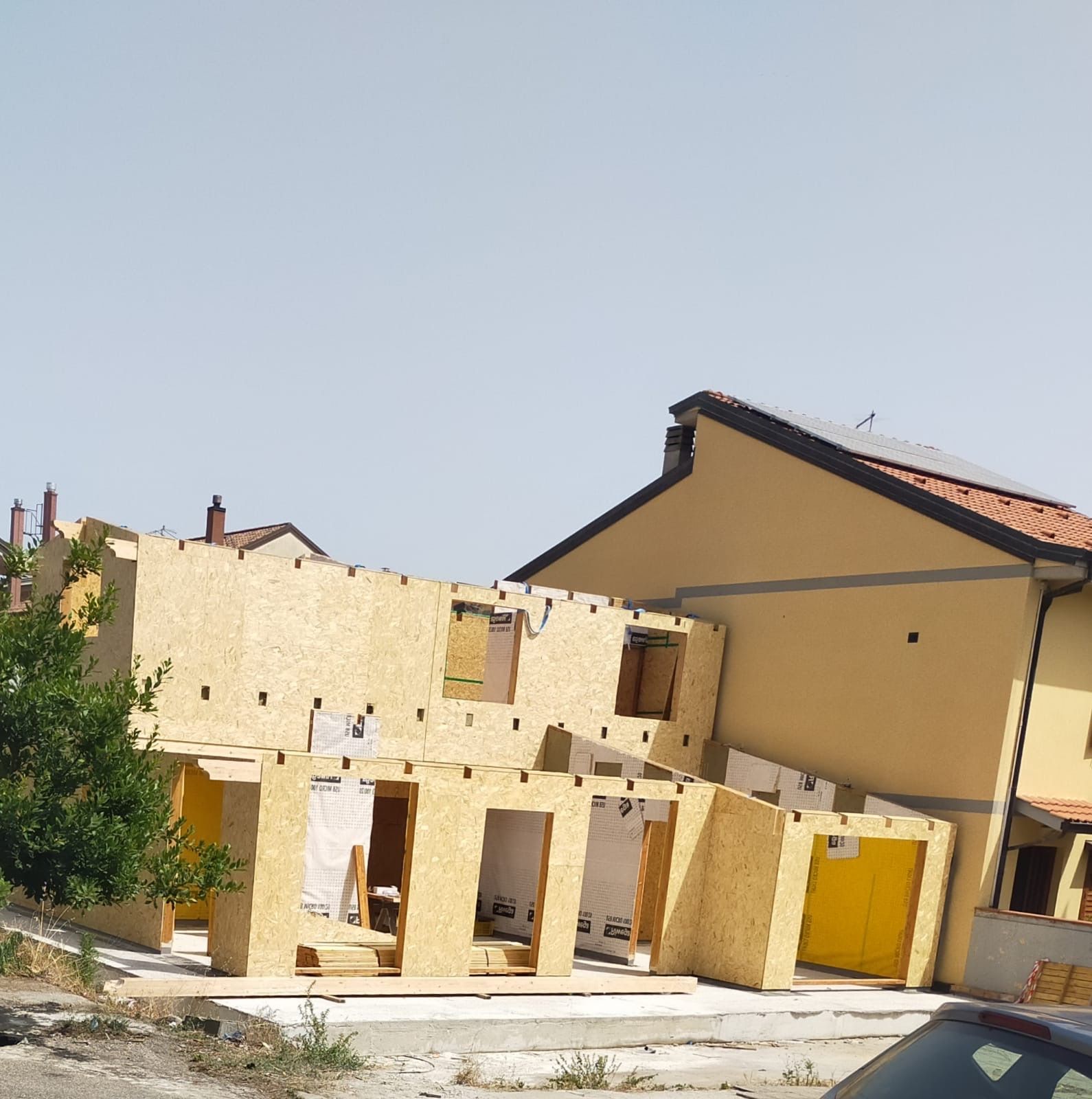 Un'auto è parcheggiata davanti a un edificio in costruzione