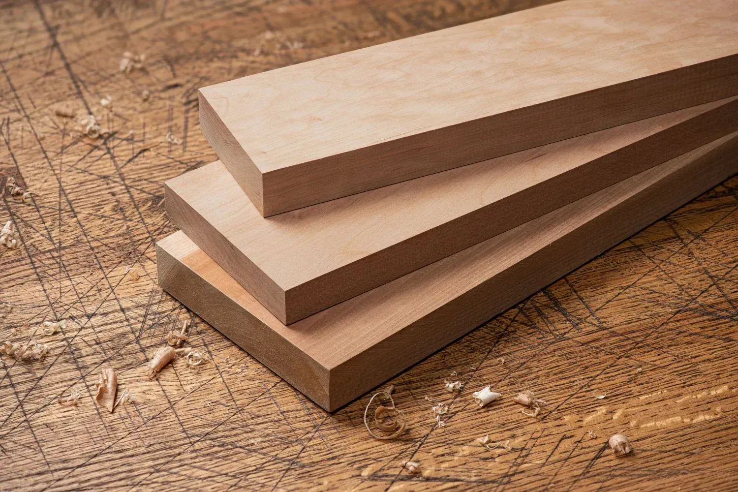 Three pieces of wood are stacked on top of each other on a wooden table.