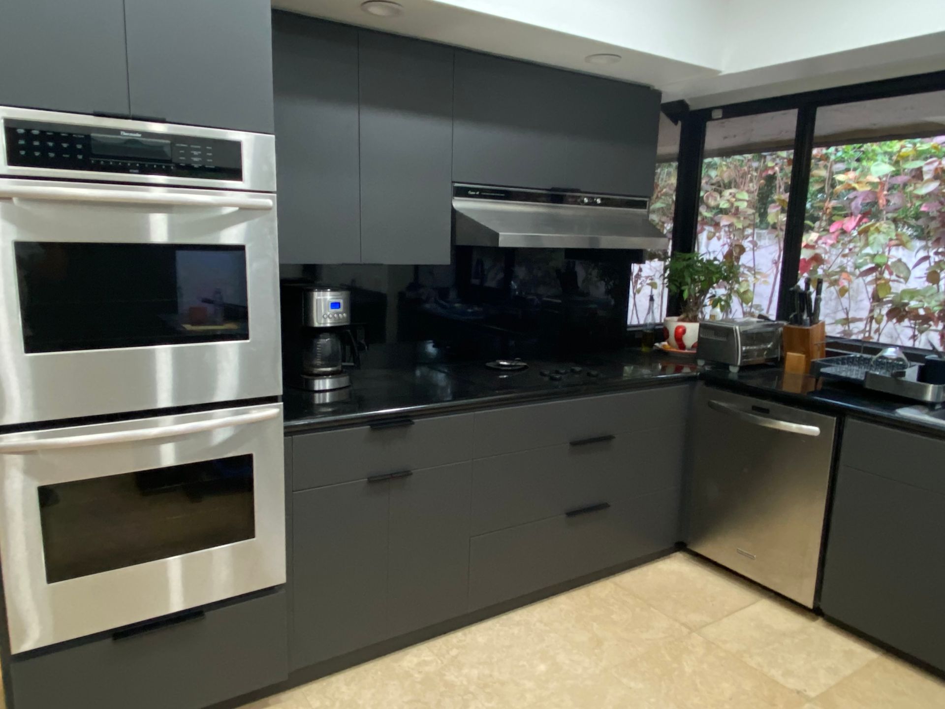 Grey Kitchen cabinets with Black countertops here in Miami, FL