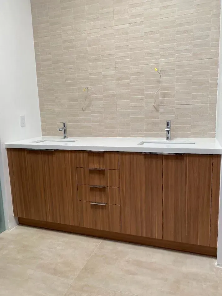 A bathroom with two sinks and wooden cabinets.