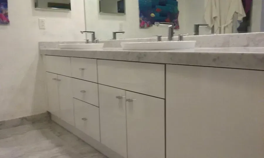 A bathroom with two sinks and a mirror.