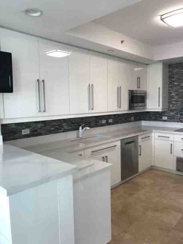 A kitchen with white cabinets and stainless steel appliances.