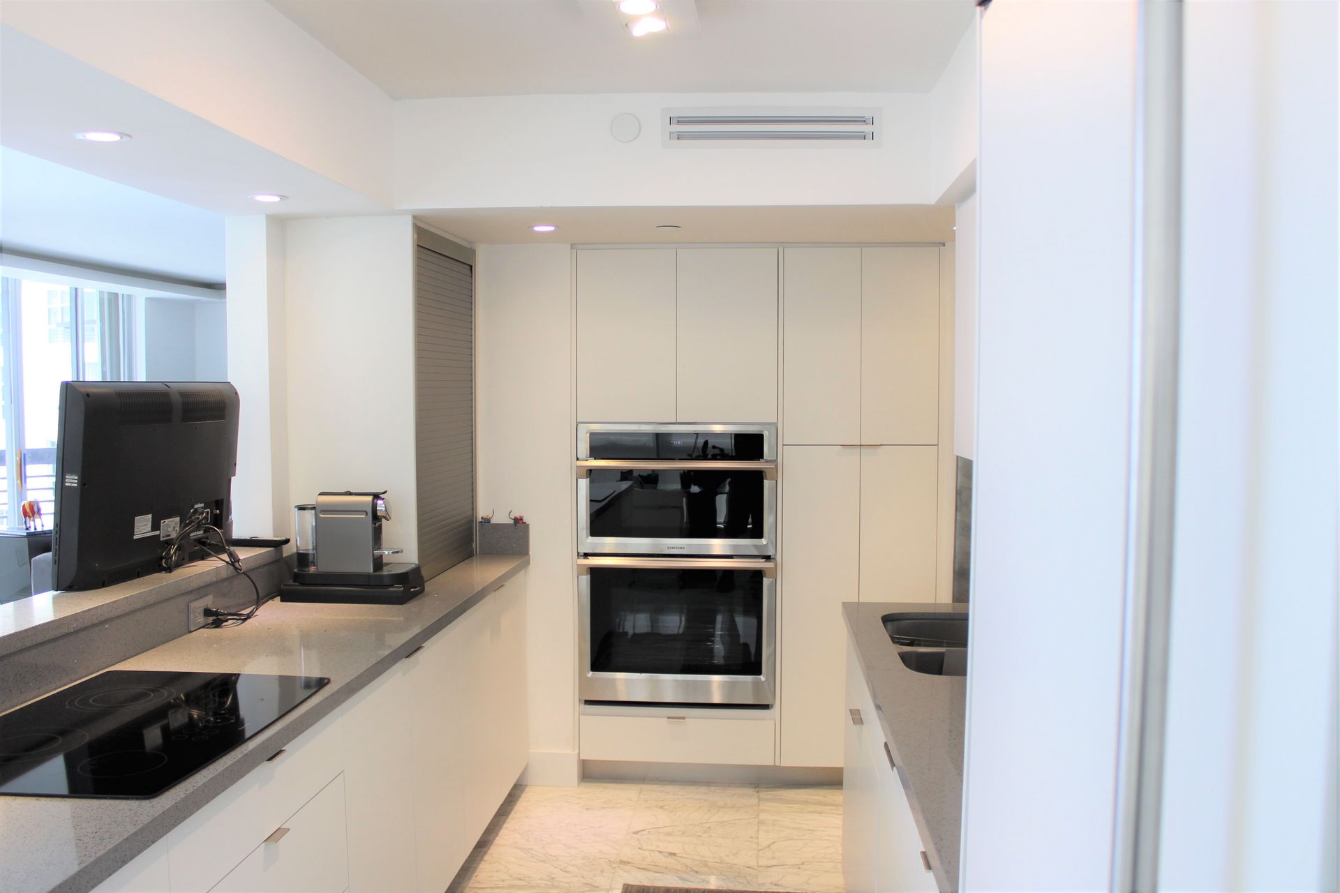 White cabinets with stainless steel appliances and quartz countertop