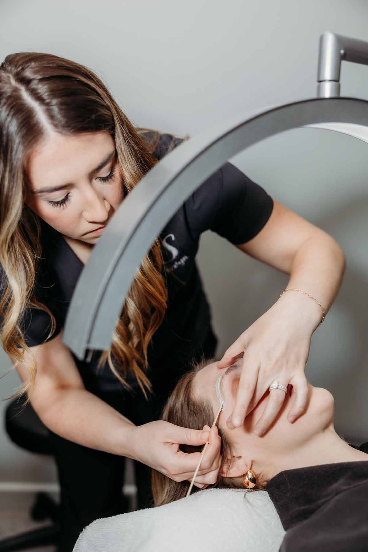 Facial massage treatment in a spa, with a therapist applying cream to a relaxed client