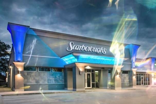 Sambourne's storefront at dusk with blue-lit facade and glass entrance