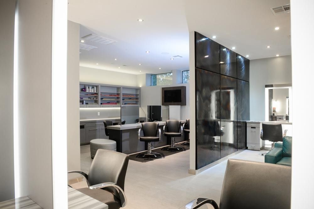 Modern office reception area with gray chairs, white walls, and glass partitions