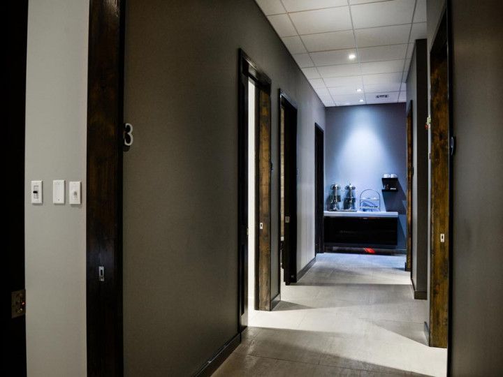 Dim hallway with open doors leading to a small office and desk at the end.