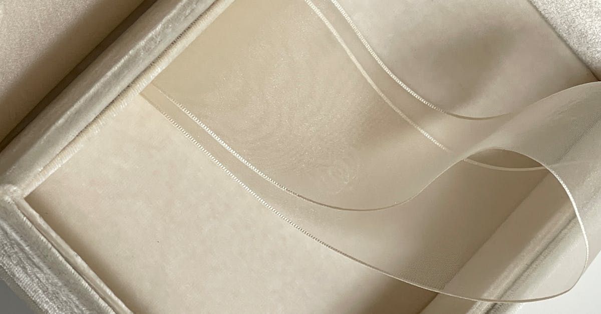 A close up of a white box with a ribbon in it.