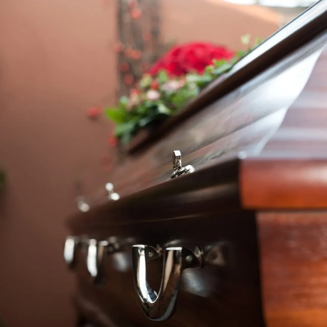 A close up of a coffin with flowers in it