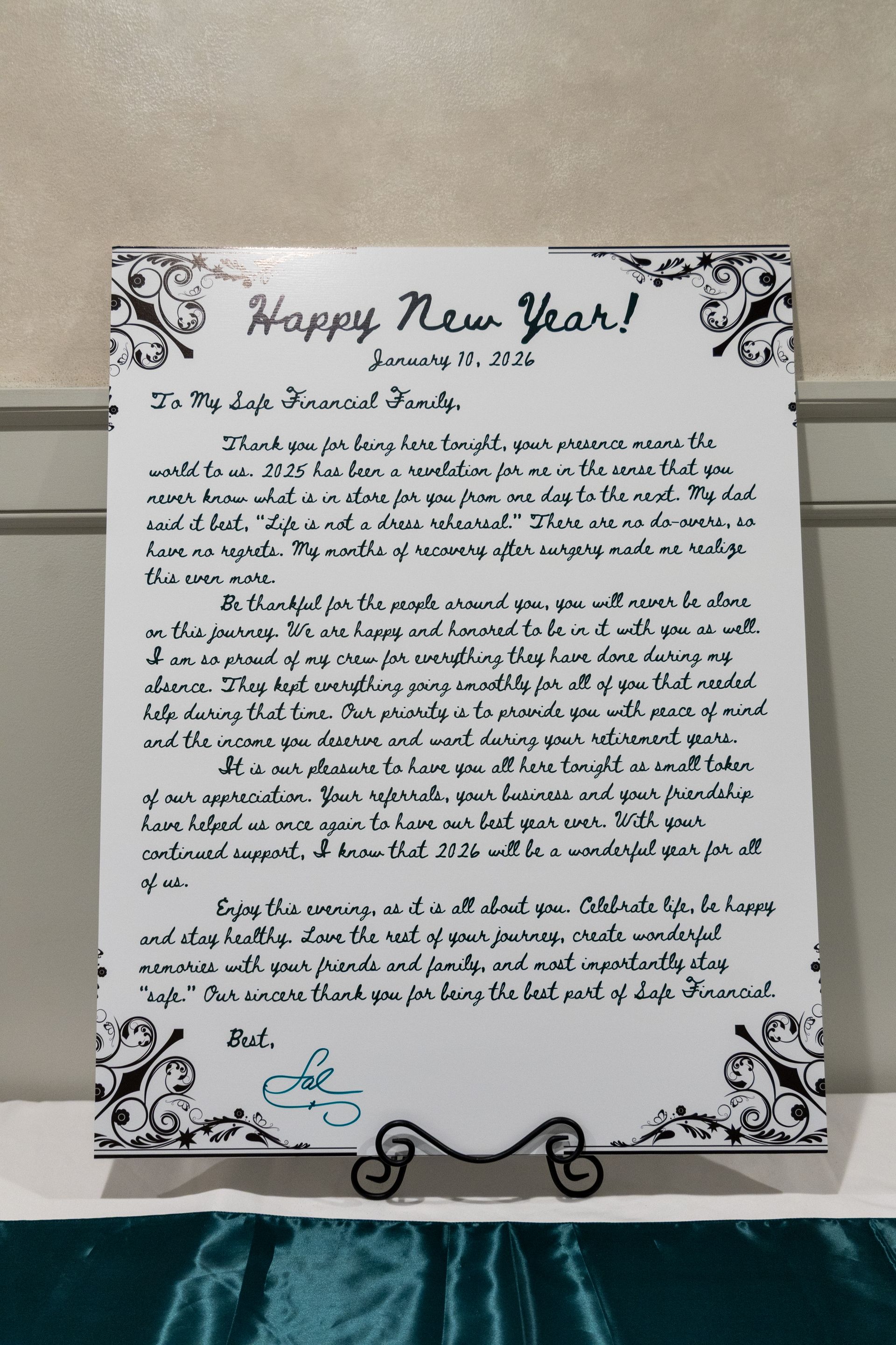 White sign with black ornate border. Text: 