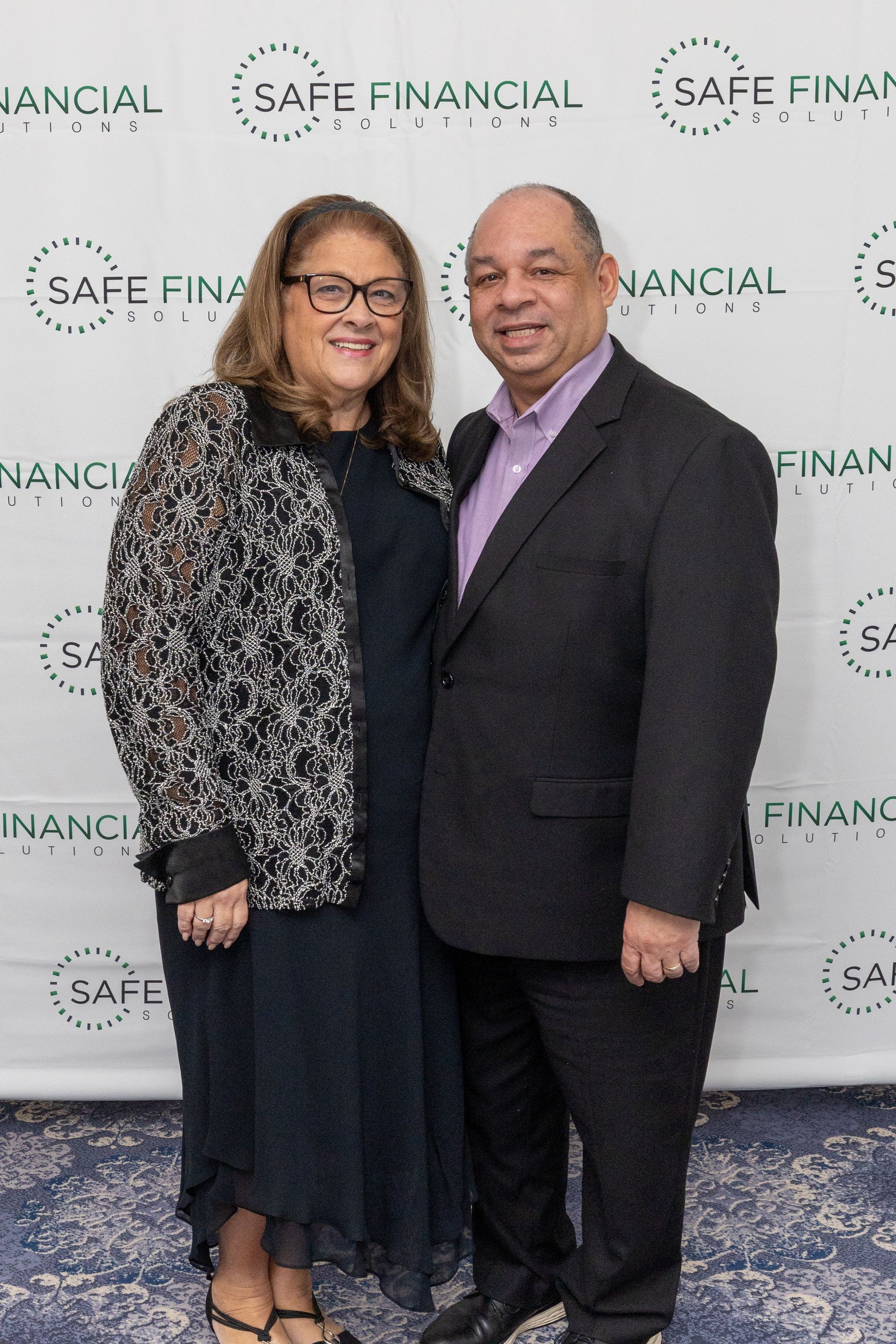 Couple posing at an event with a green and white 