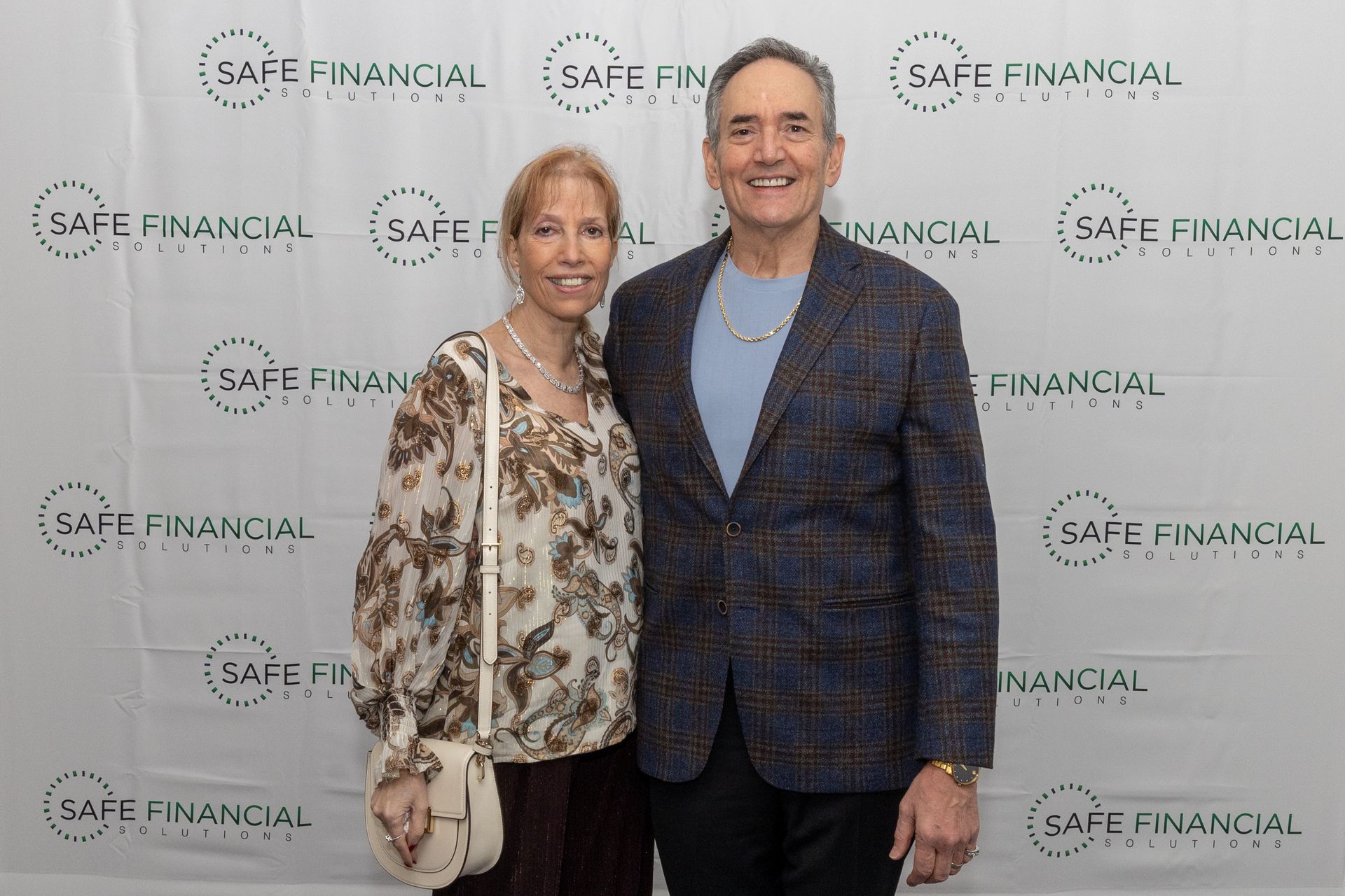 Couple posing in front of a backdrop with 