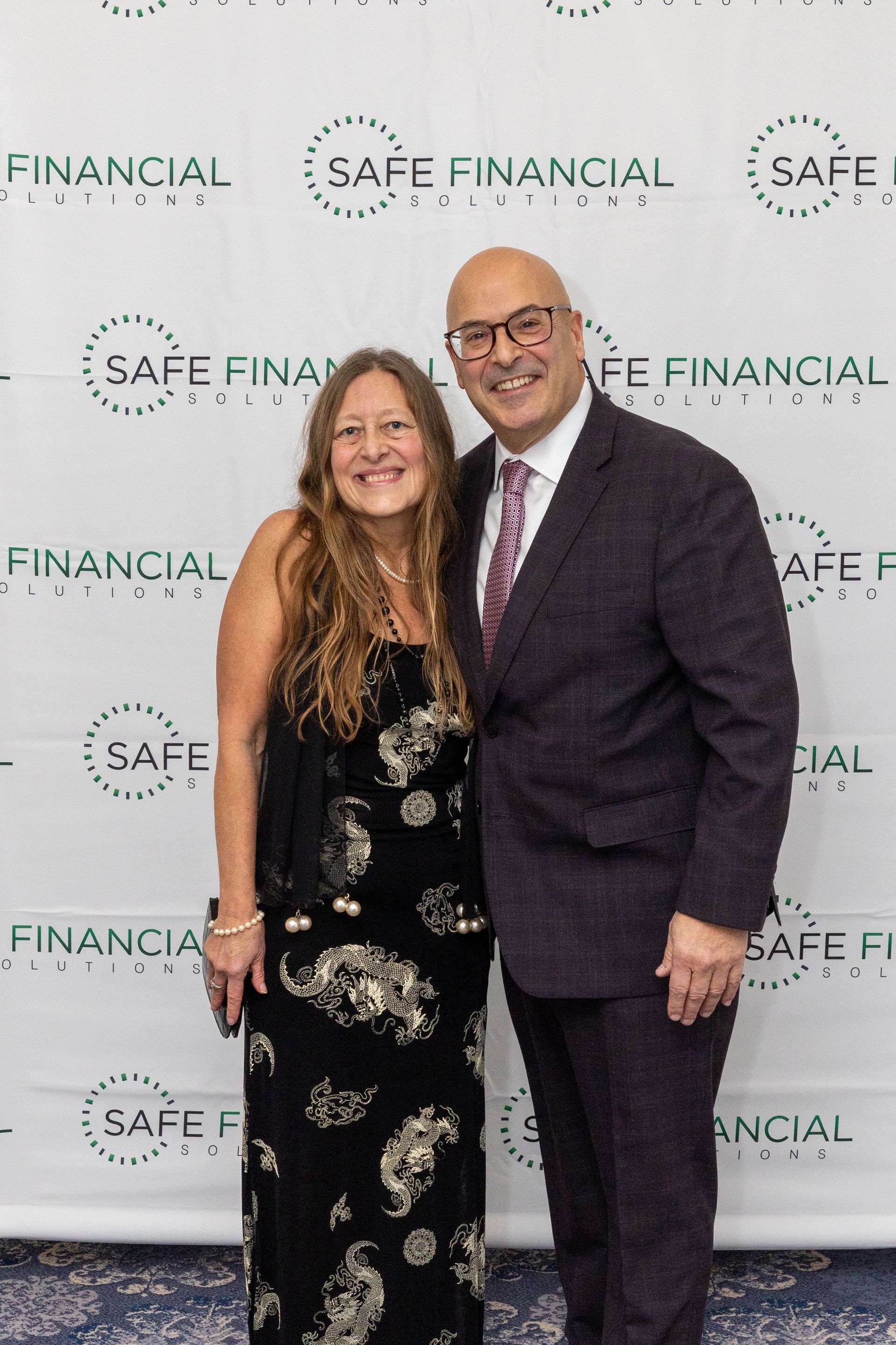Couple poses in front of a backdrop with 