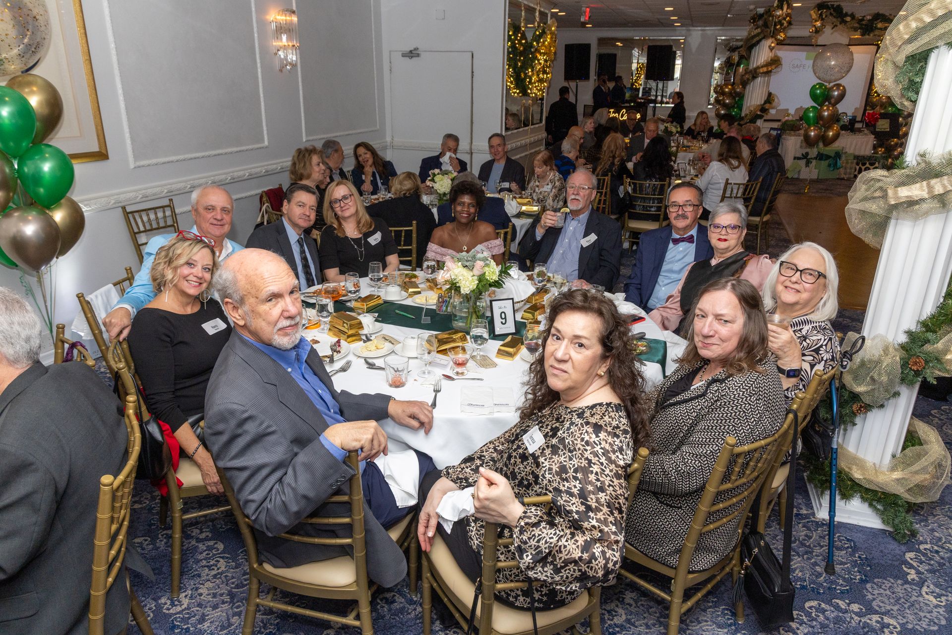 People seated around a decorated table at a formal event, likely a party.