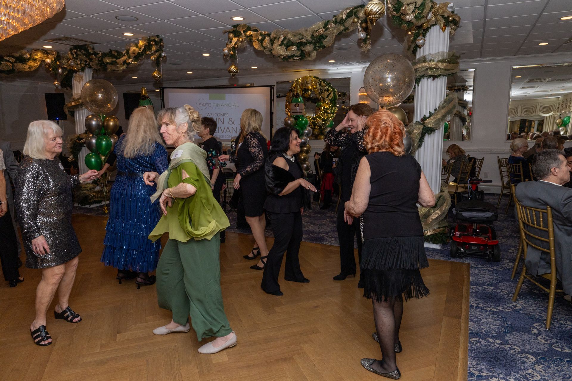 People dancing at a party in a decorated room with balloons.
