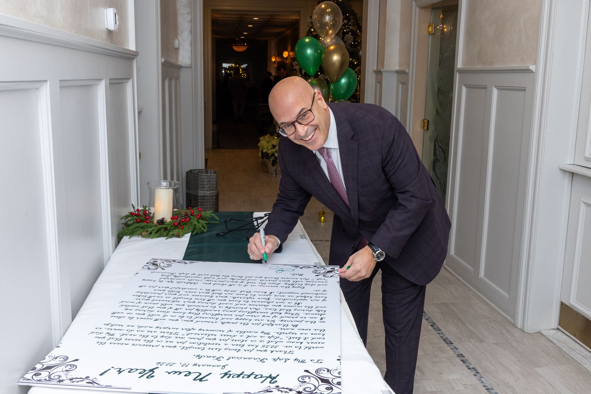 Man signing a large white banner with a 