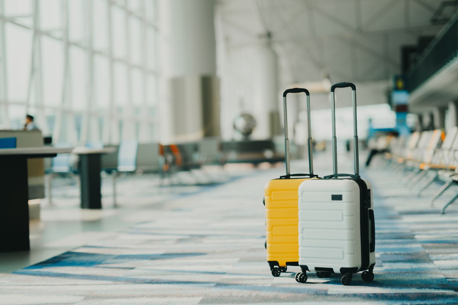 Due valigie sono appoggiate sul pavimento di un aeroporto.