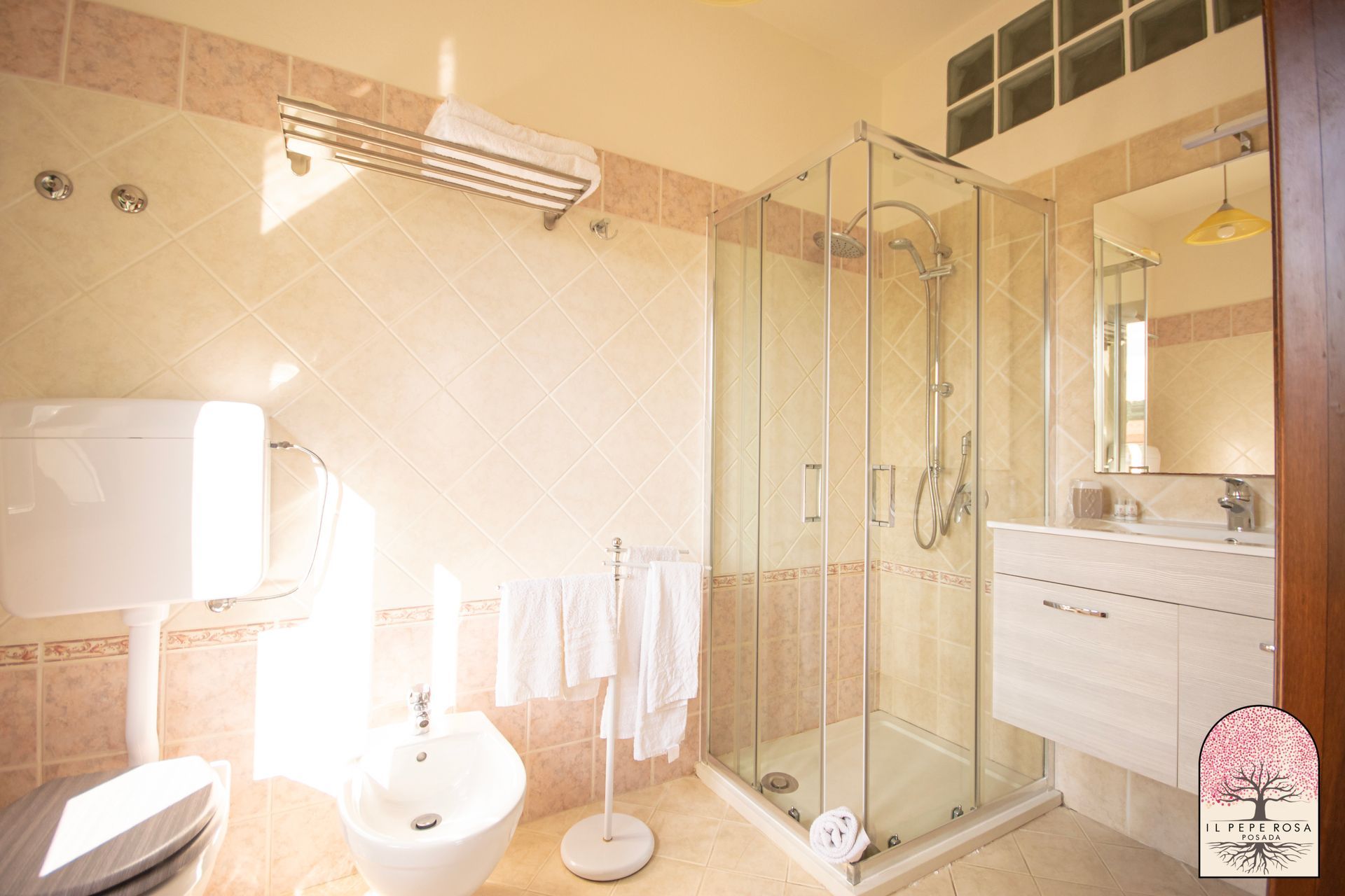 Un bagno con wc, lavandino, doccia e specchio