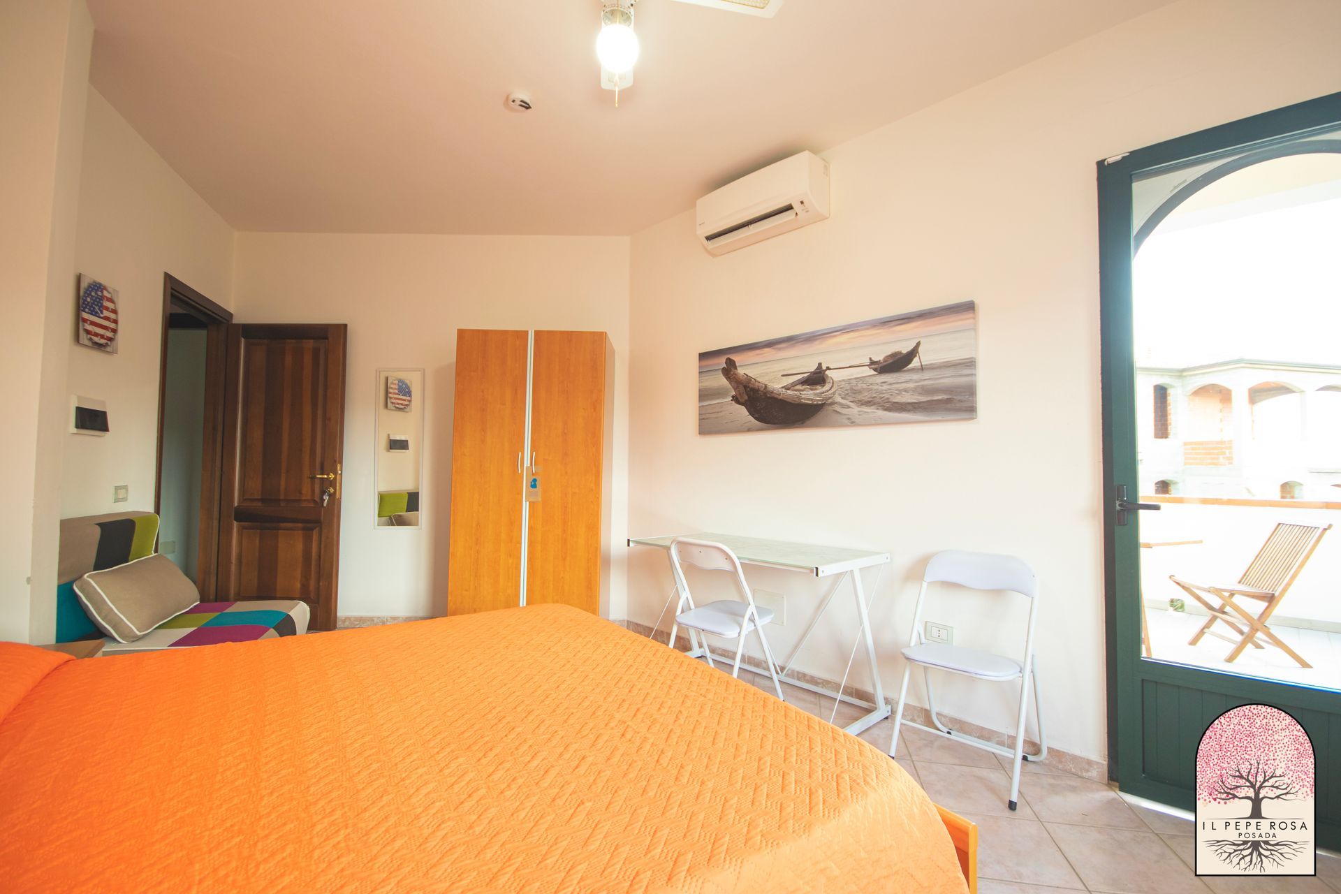 Una camera da letto con un letto, un tavolo, delle sedie e un quadro sul muro.