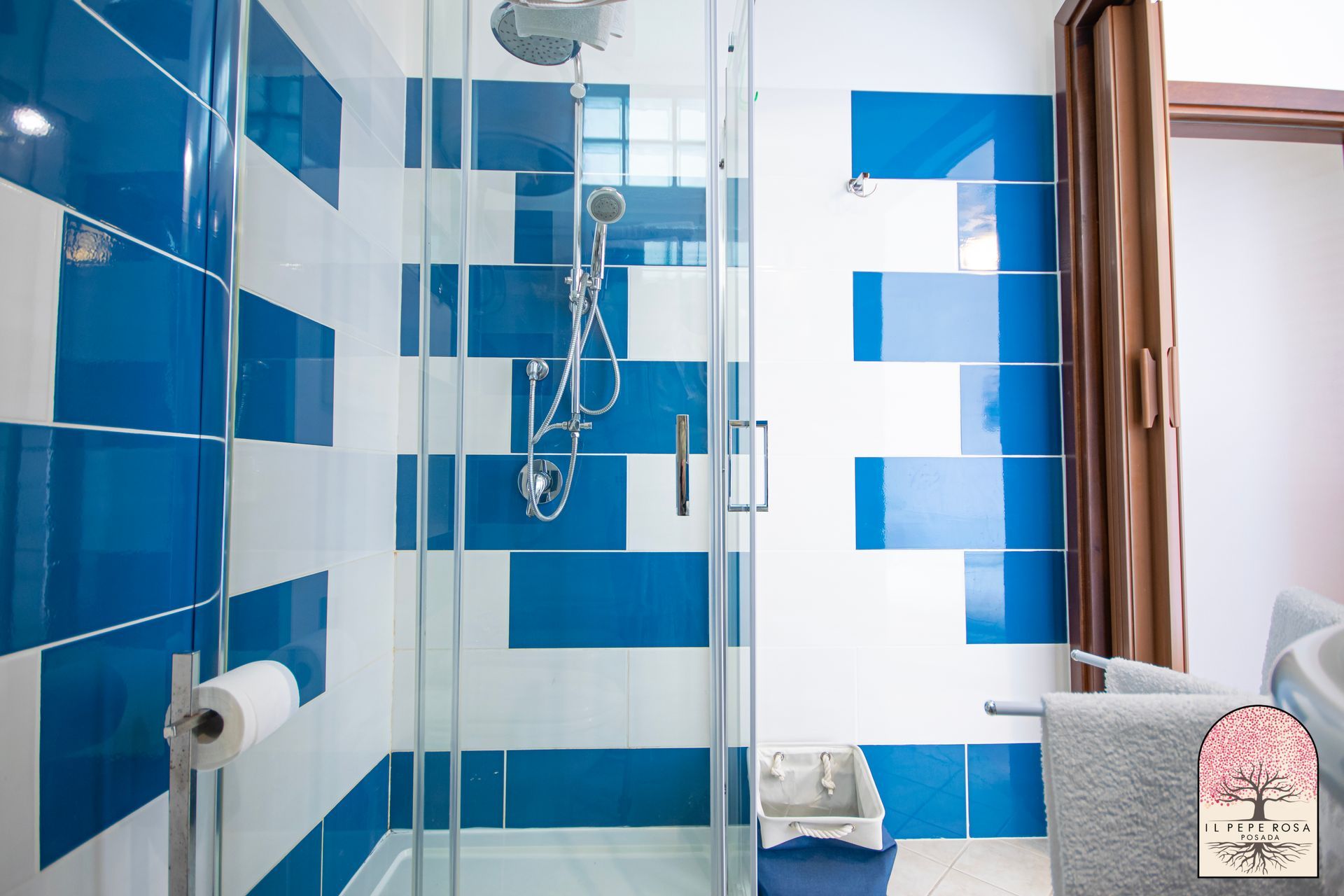 Un bagno con piastrelle blu e bianche e una cabina doccia