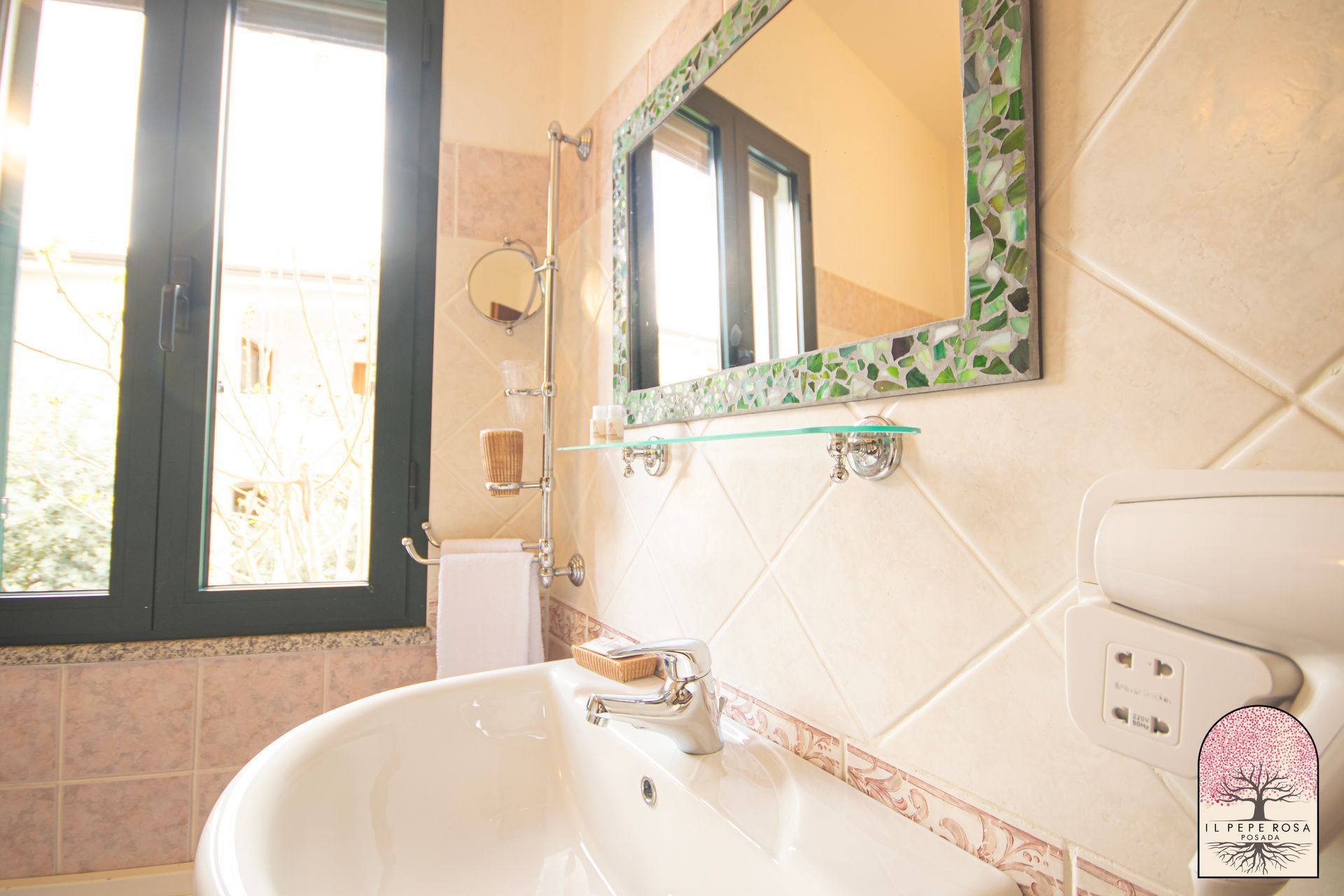 Un bagno con lavandino, specchio e finestra