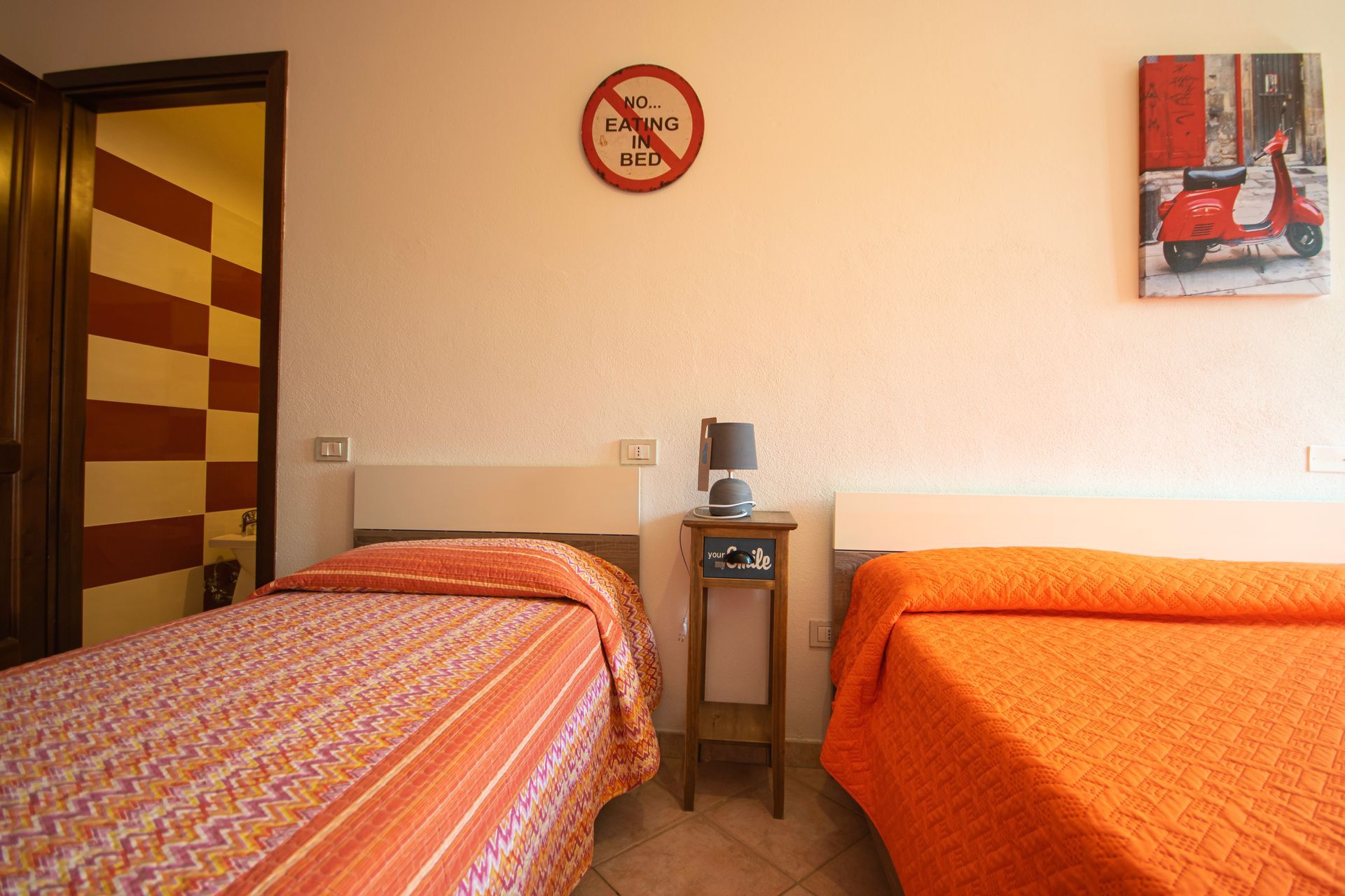 Una camera da letto con due letti e un quadro sul muro
