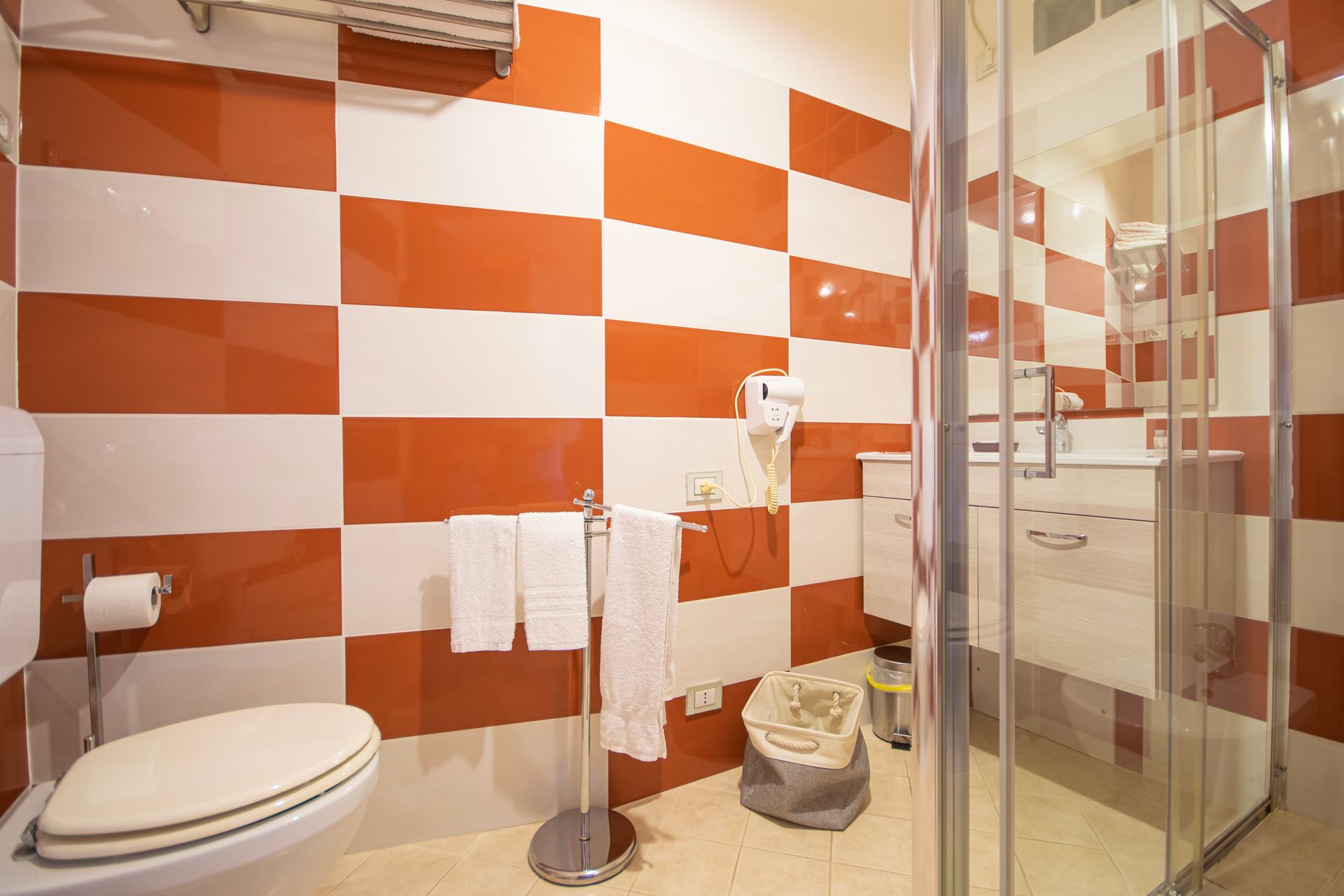 Un bagno con piastrelle rosse e bianche e un water.