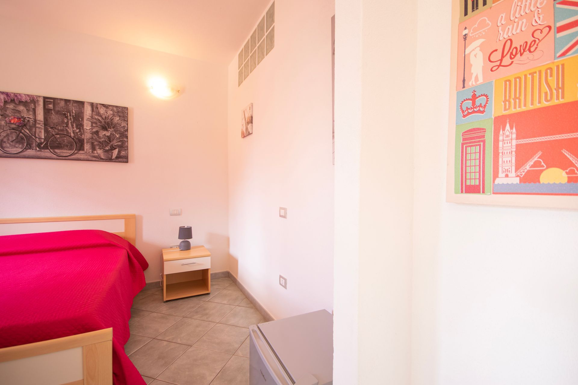 Una camera da letto con un letto, un comodino e un poster sul muro.