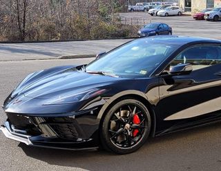 A black sports car is parked on the side of the road