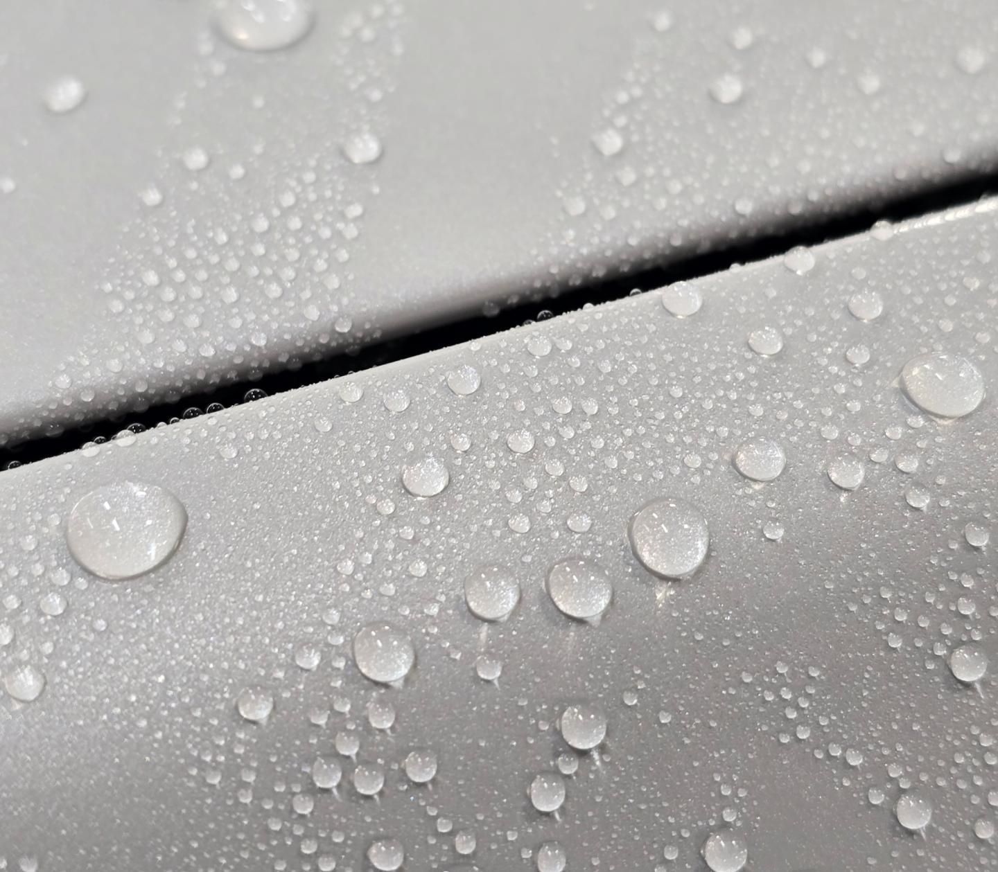 A close up of water drops on a metal surface.
