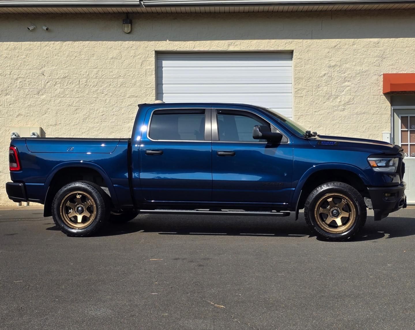 A blue truck is parked in front of a building