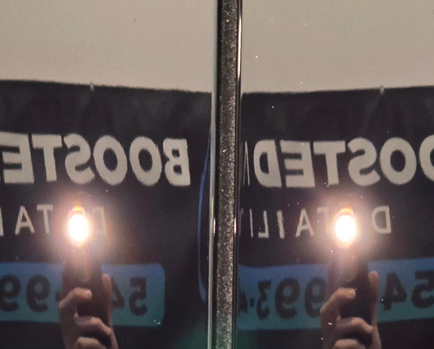 A person taking a selfie in front of a sign that says et2008