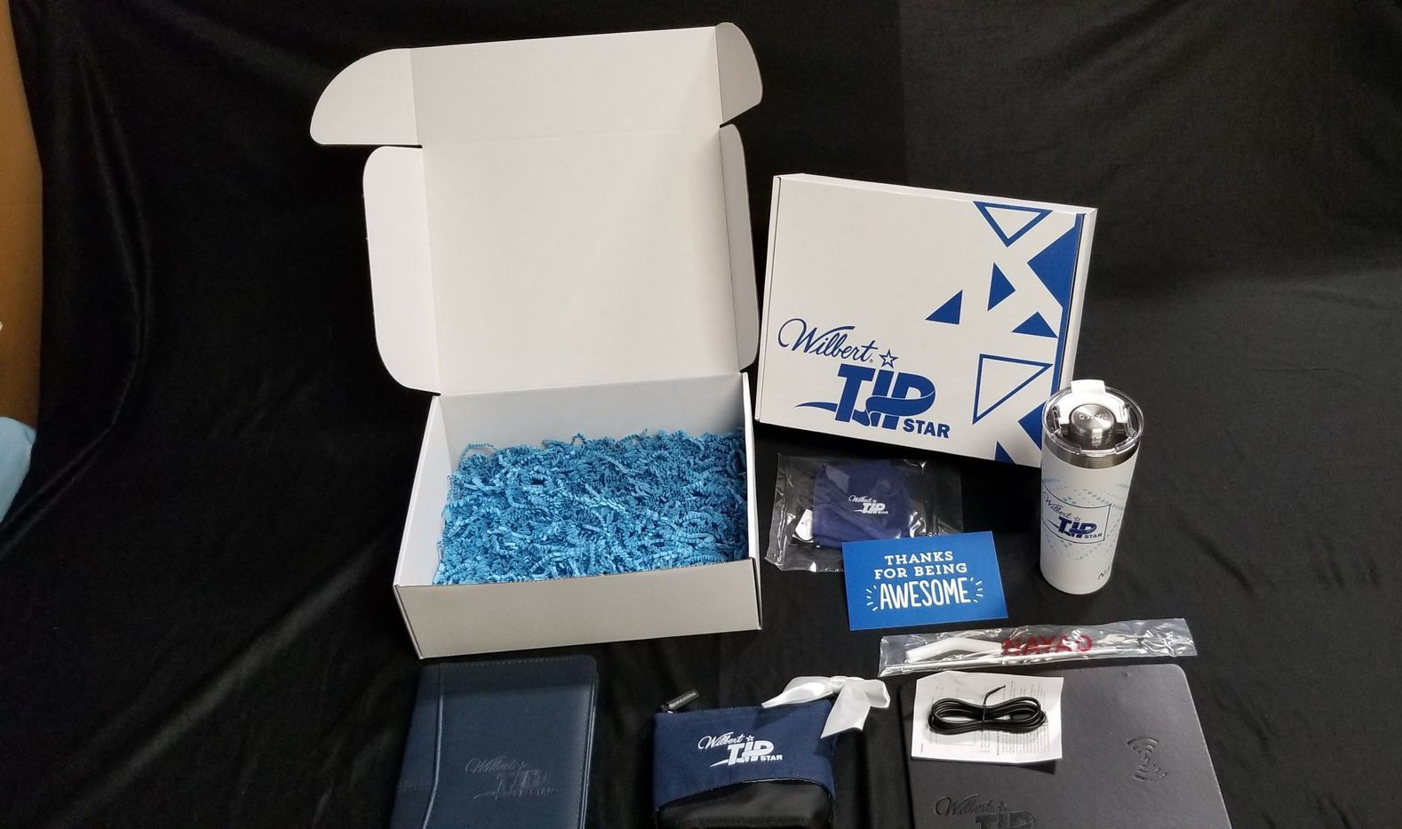 Custom printed welcome kit box with tumbler, notebook, socks and tech accessories for a Louisville KY company