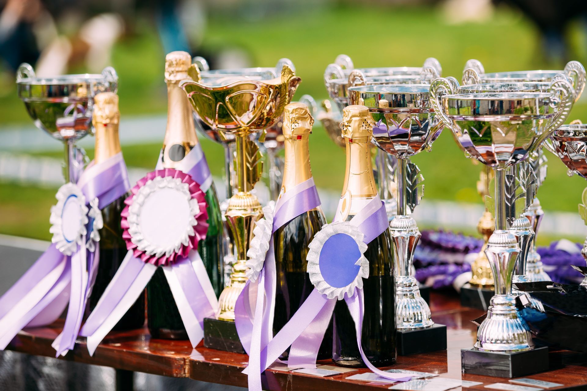 Silver and gold trophy cups with purple ribbons for employee recognition events in Louisville KY