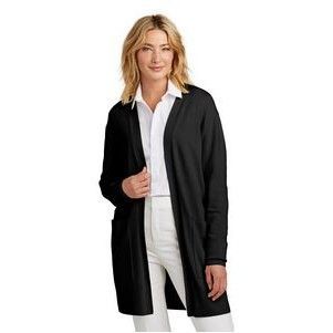 A woman is wearing a black cardigan and white pants.