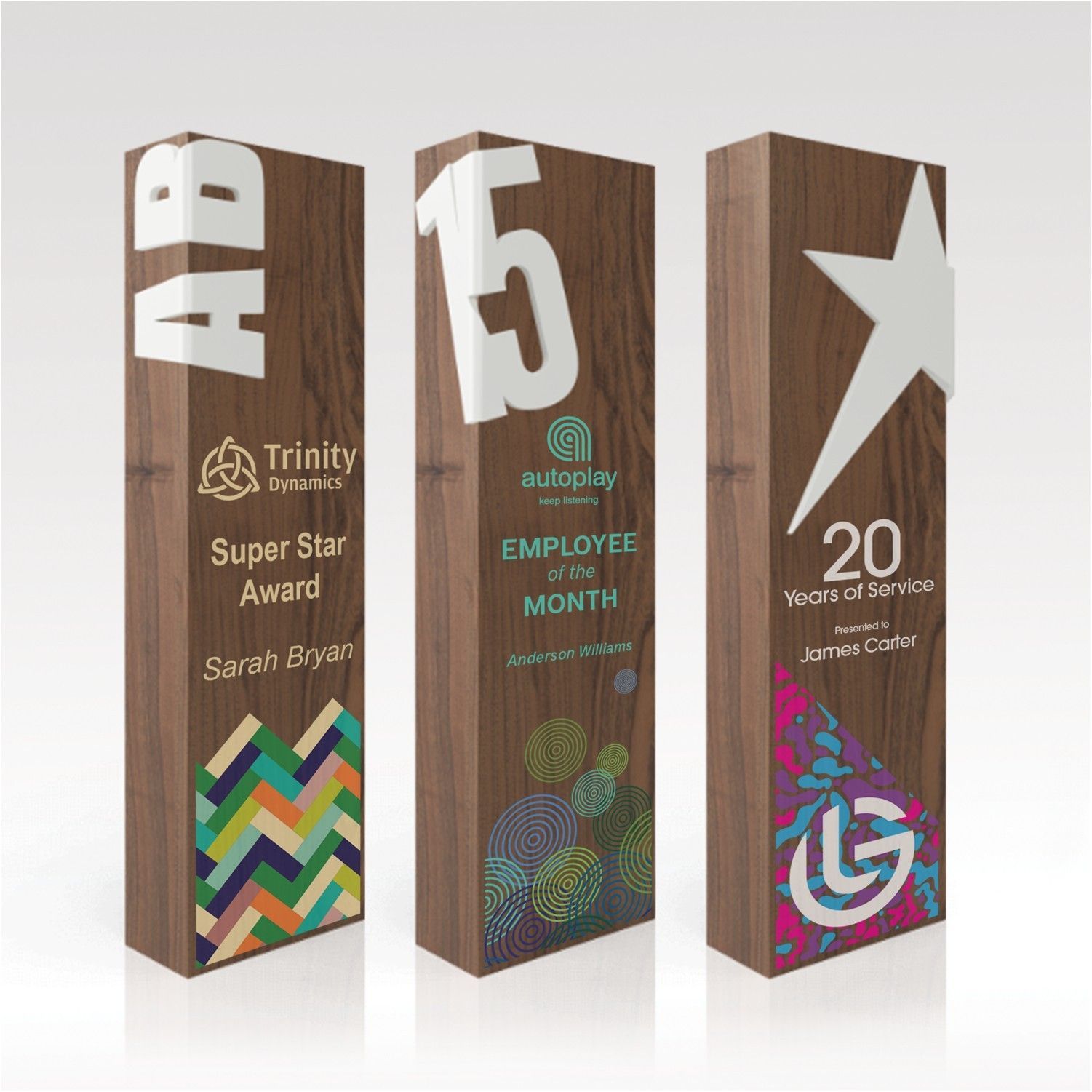 Three wooden trophies are sitting next to each other on a white surface.