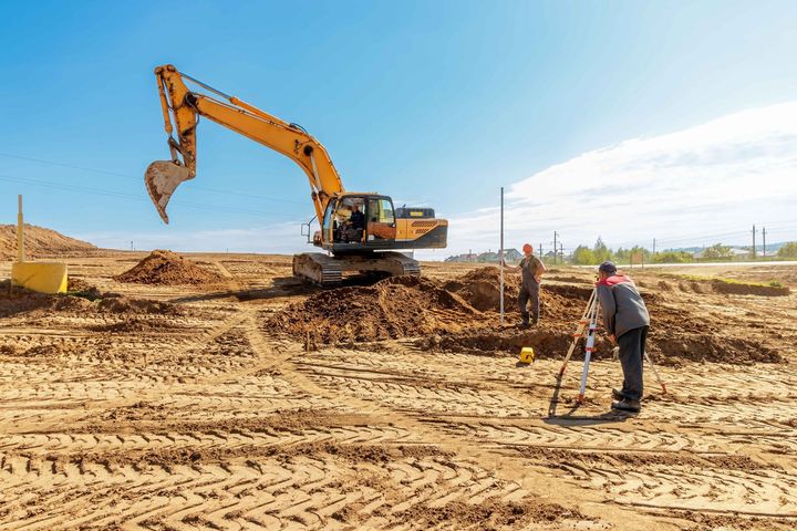 an excavator is digging a hole in the dirt on a construction site