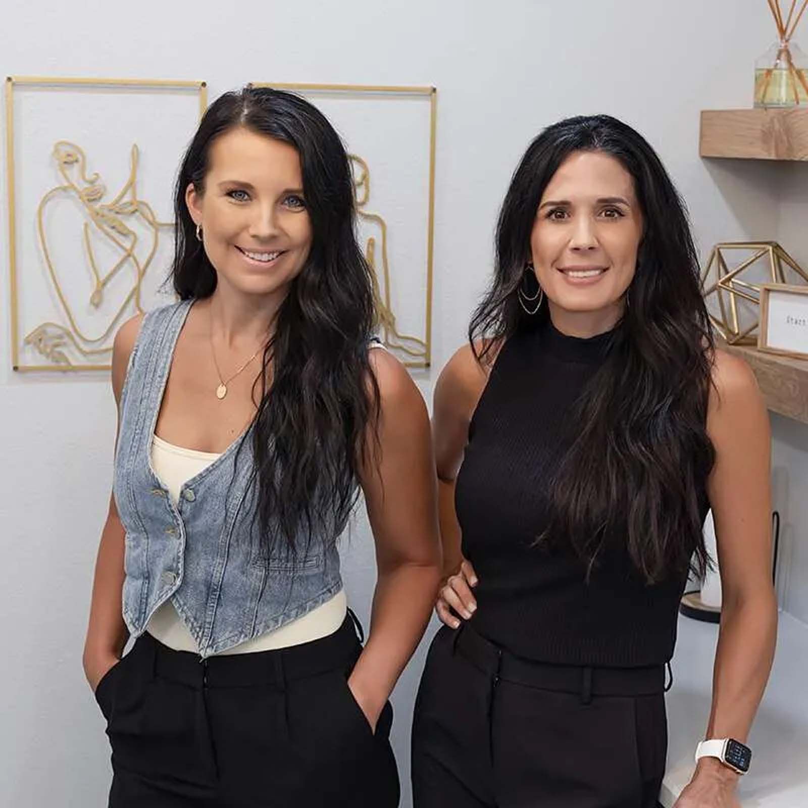 Two women standing next to each other with their hands in their pockets