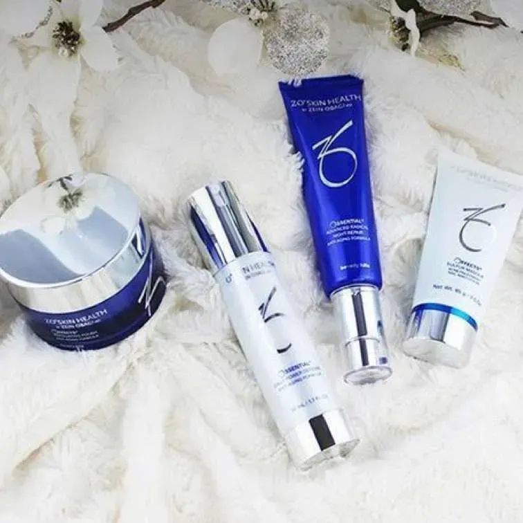 Four bottles of obagi skincare products are sitting on a white blanket