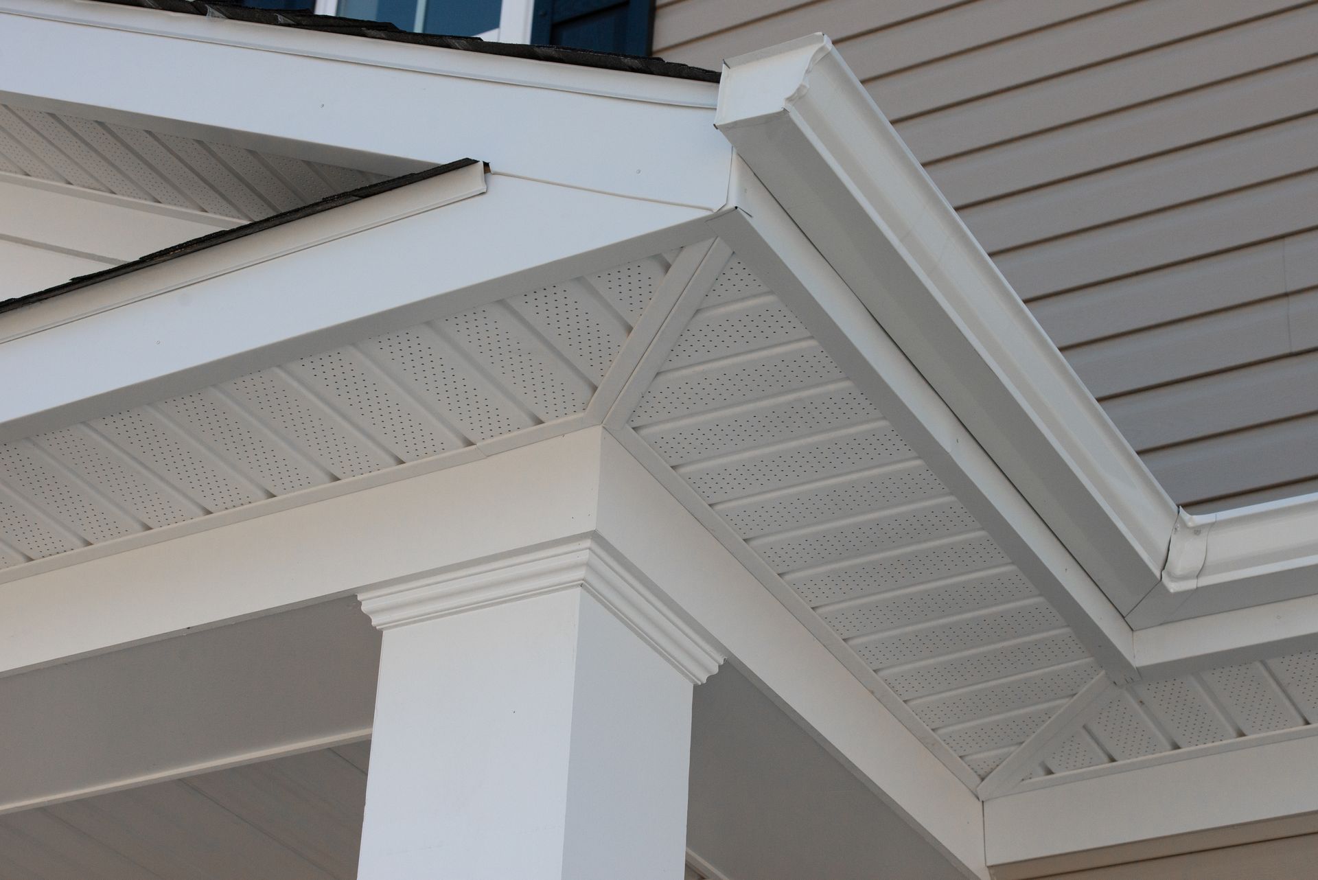 White house exterior detail with column, soffit, and siding.